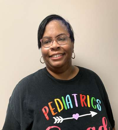 A woman wearing a black t - shirt that says pediatricians are great.