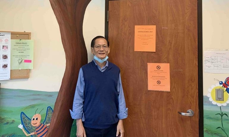 A man standing in front of a door in an Houston classroom.