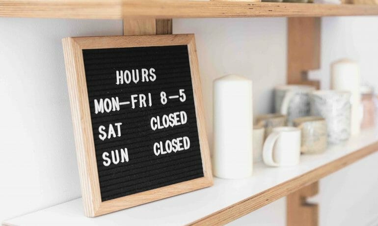 A wooden shelf with a blackboard that reads hours fri - fri - sat sun.