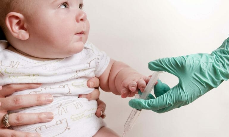 A woman in Services Sugar Land is giving a baby a vaccine during a well child check.