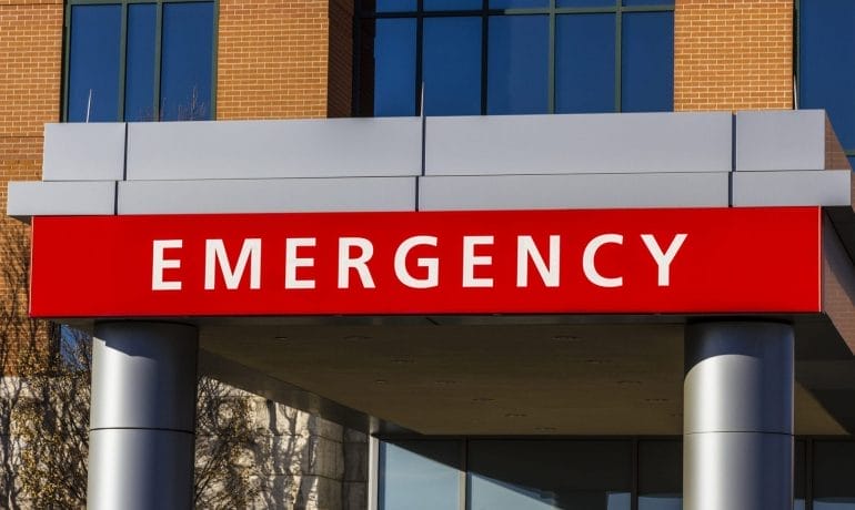 An emergency sign in front of a building.