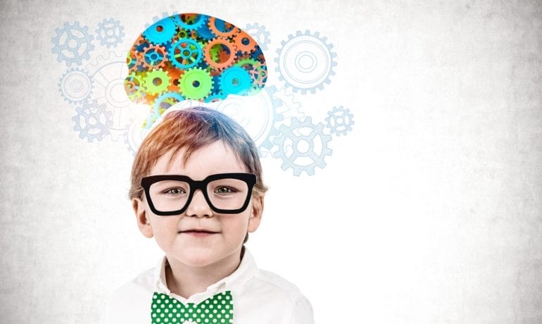 A young boy wearing glasses and a bow tie with gears on his head.