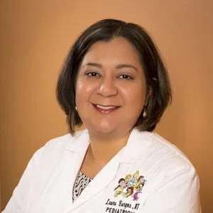 Pediatrician Laura M. Burgos-Orta posing for a photo in a white coat.