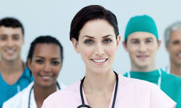 A group of nurses standing in front of a white background.
