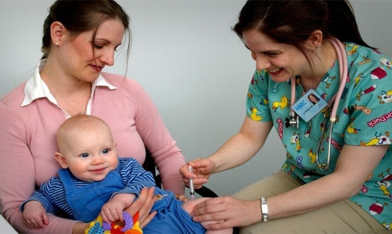 A baby is receiving vaccines in a doctor's office.
