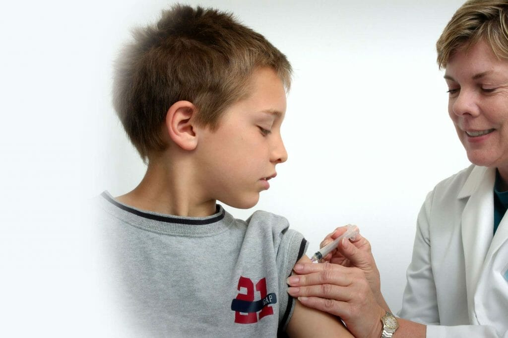 A young boy receiving a vaccination from a doctor.