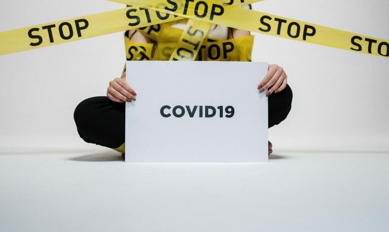A woman holding a sign promoting a pediatric vaccine that protects against coronavirus.