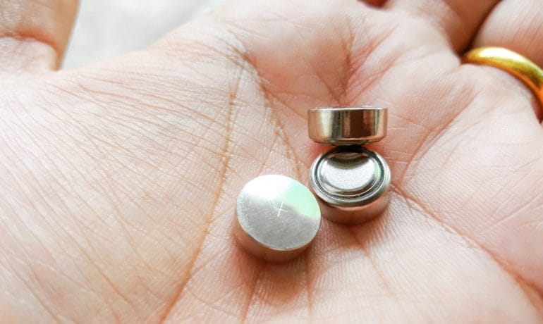 A person's hand with a small metal ball in it.